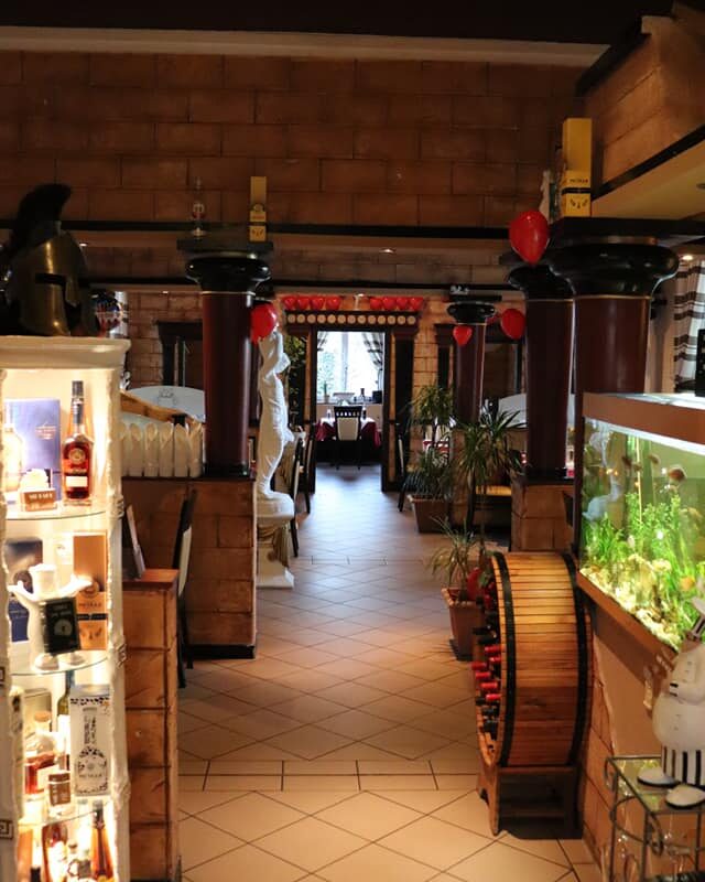 Blick durch den Gastraum mit Weinregal und Aquarium