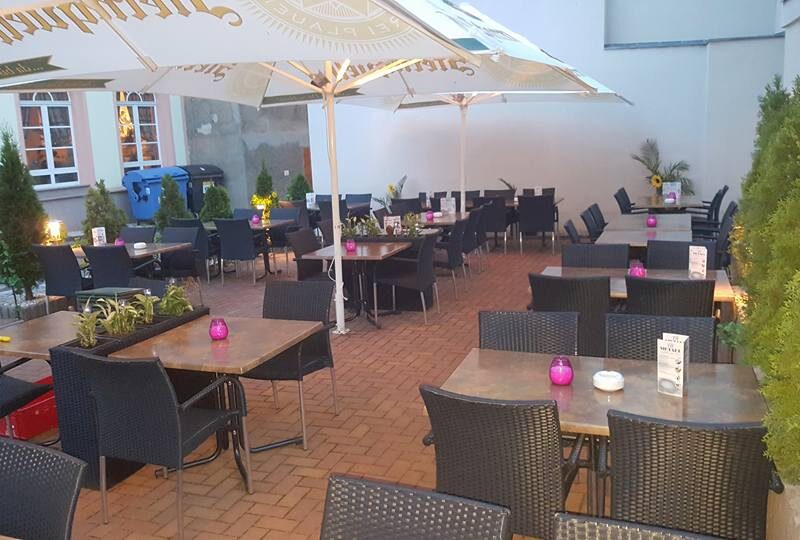 Sonnige Terrasse mit Sonnenschirmen und Sitzgruppen